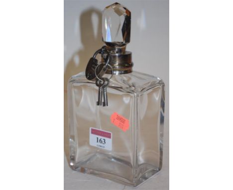 A square glass decanter and stopper having silver collar and locking mechanism