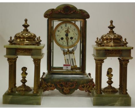 A late 19th century French gilt brass and green onyx mantel clock, with associated later garniture, the clock having white en