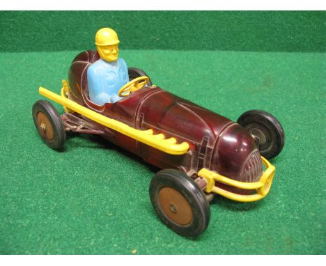 Metal and plastic model of a mid 20th century racing car with sparking engine within the transparent red body shell, tyres ma