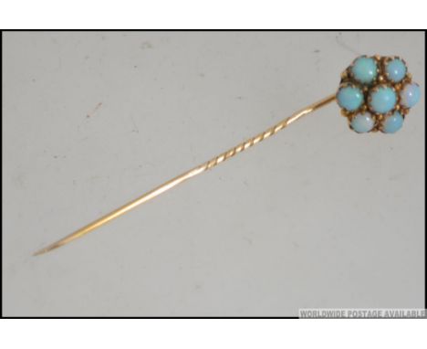 An 18ct gold ( tested ) and 7 stone opal stick - hat pin. Measures 5.5cms long / weight 1.7g