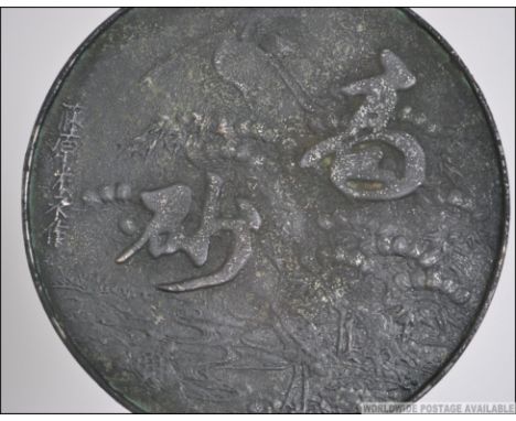 A 20th century Chinese / Japanese bronze hand mirror relief decorated with character marks to the verso of the mirror. Measur
