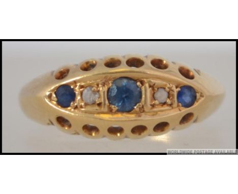 An  Edwardian 18ct gold sapphire and diamond ring. The central sapphires with diamonds raised on a pierced setting. Diamonds 