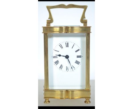 A good brass carriage clock with glass facia and shaped handle. open escapement top with window under shaped handle. Measures