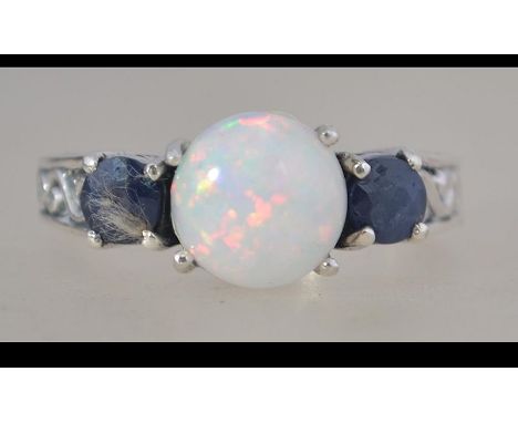 A silver, sapphire and opal adorned 3 stone ladies dress ring. Total weight 5.3g / Size R.5. Complete in presentation case