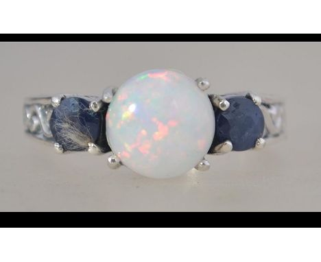 A silver, sapphire and opal adorned 3 stone ladies dress ring. Total weight 5.3g / Size R.5. Complete in presentation case