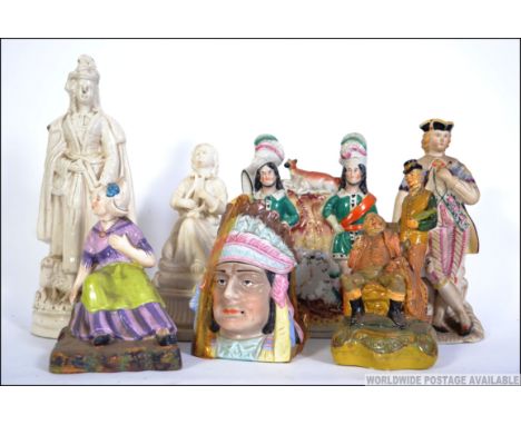 A collection of figurines to include a 19th century Staffordshire flatback, a Staffordshire flatback of Queen Victoria, Red I