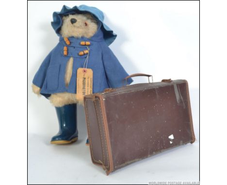 A Gabrielle Designs Paddington Bear, circa 1975, dressed in blue felt hat, coat and Dunlop Wellington boots, height 44cm alon