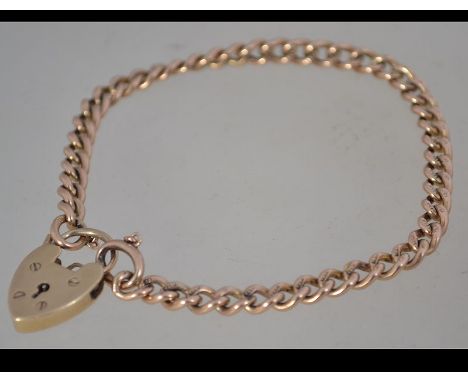 A 9ct gold chain link bracelet with heart lock. Hallmarked for London.  Weight 12.5g. Measures 7 inches.