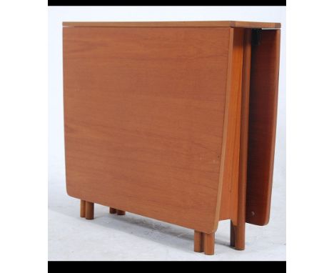 A 1970's teak wood drop leaf dining table raised on bow end legs with turned feet having gate leg action supporting the leave