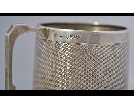 A silver hallmarked engine turned decorated Christening mug with Birmingham assay stamp, makers mark for F.H.A & P dating to 