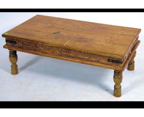 A late 20th century rustic pine coffee table raised on turned legs with metal bracket work