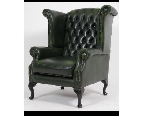 Antique Chesterfield Style mahogany and leather button back armchair being raised on cabriole legs upholstered in green leath