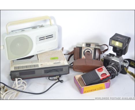 A Nikon FG slr camera with lens and flash together with a Roberts RP15 radio, retro 1980's Matsui cassette radio alarm clock 