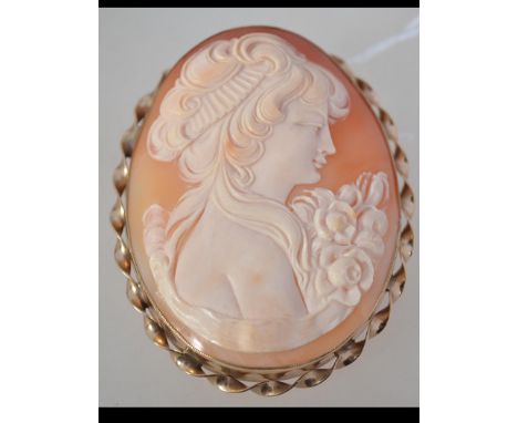 A large 9ct gold shell cameo brooch with safety chain. Measures 2.5 inches. Total weight 24g.
