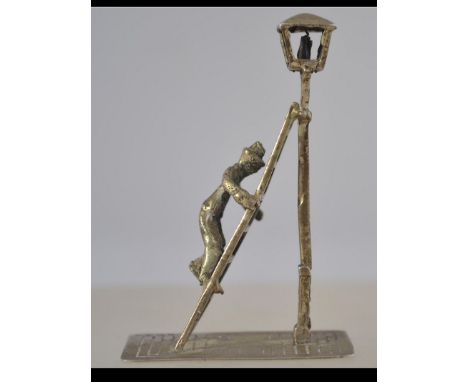 A silver hallmarked figurine believed Dutch with Rotterdam marks of a lamplighter up his ladder lighting the street light.