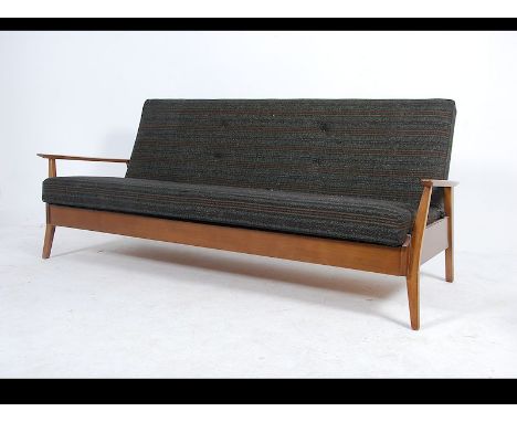 A 1960's Danish inspired sofa day bed with the original upholstered seat/ bed being raised on tapering legs with sloped elbow