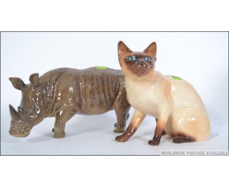 A SylvaC ceramic figurine of a rhino together with another SylvaC figurine of a Siamese cat. Measures: 18cms high.