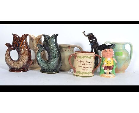 A collection of ceramics to include a USSR ceramic figurine of an otter with a fish, mottoware loving cup, puzzle jug, Burlin