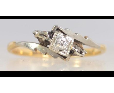 An early 20th century 18ct gold  and platinum diamond ring set with a central diamond with scalloped crossover shoulders. Siz