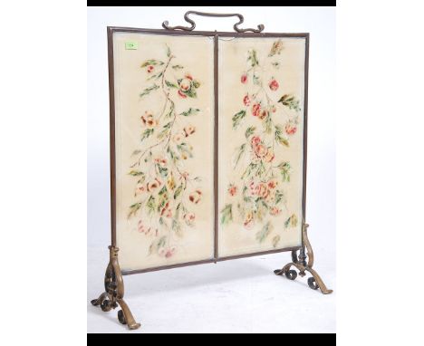 A large early 20th century Arts & Crafts brass and bevelled glass fire screen. Raised on scrolled supports with tapestry inse