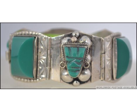 A silver stamped 925 Sterling six sectional panel bracelet. Each panel with inset polished glass jade style stone in the form