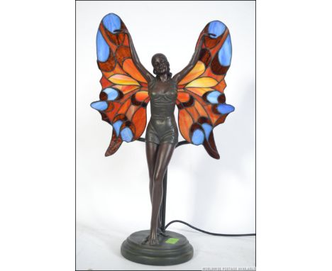 A contemporary Tiffany style table lamp being wired having a central nymph figure with coloured glass wings acting as a shade