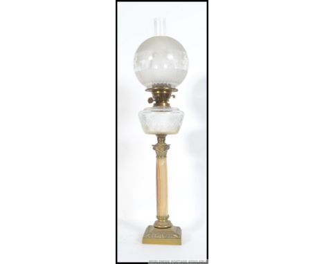 An early 20th century brass and marble oil lamp raised on a three tier square base with marble column holding the glass reser