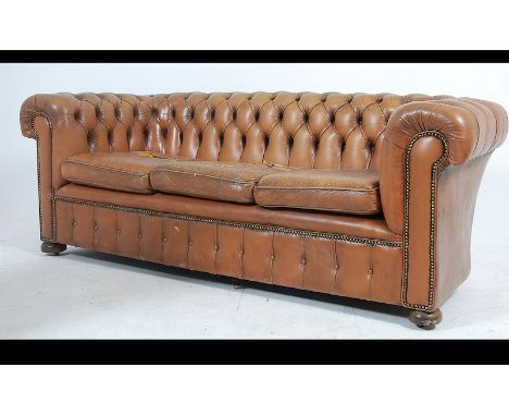 A 20th century brown leather chesterfield sofa settee with barrel arms and back rest having upholstered button backed leather