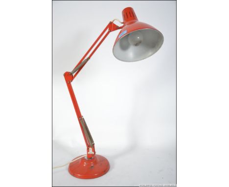 A retro 1001 anglepoise desk lamp in original orange paint having applied label. Raised on circular base with pendant shade