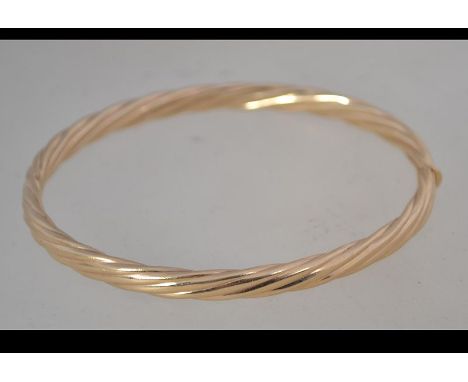 A hallmarked 9ct gold bangle bracelet with hidden clip clasp. Hallmarked Sheffield. Weight 10.4g