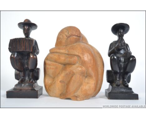 A pair of mid 20th century wooden carved bookends of a man playing an accordion and a man drinking together with another wood