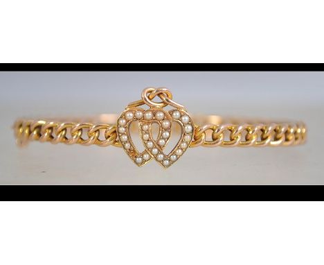 A 15ct gold and seed pearl bracelet with entwined heart motif set with seed pearls with knot having a chain bangle with with 