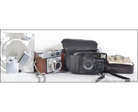 A collection of cameras to include digital and vintage with makes such as Kodak, Nikon, a boxed James Bond JB1 007 spy camera