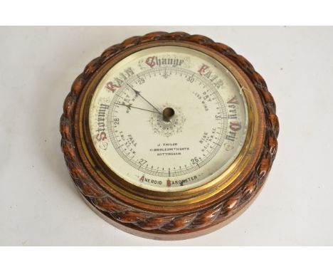 A 20th Century oak circular aneroid barometer,   marked 'J. Taylor' '11 Briddlesmith Gate, Nottingham', diameter 23cm  