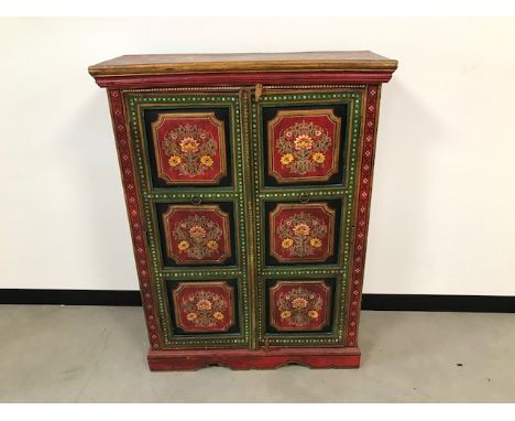 A vintage Indian cabinet, the two panel doors, sides and top all painted with flowers, 91cm wide, 121cm high and 34cm deep 