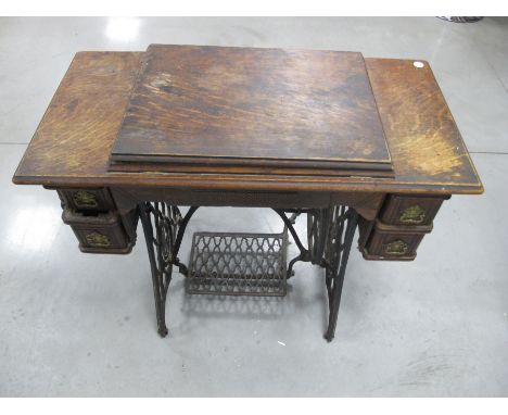 A vintage American Singer treadle sewing machine, housed in kneehole oak case with two short drawers to either side, 93cm x 4