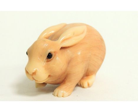 A Japanese Meiji period (1868-1912) or early Taisho (1912 - 1926) ivory netsuke in the form of a restful rabbit,  of rounded 