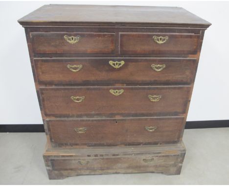 A two piece antique oak chest,  the top section having a dovetailed top with moulded edge and five cross banned graduated dra
