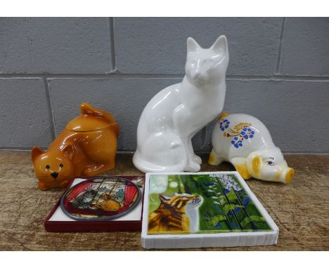 Cat related items - a painted glass plaque, a ceramic Fiesta Studios tile picture, a biscuit barrel, a model of a cat and a p