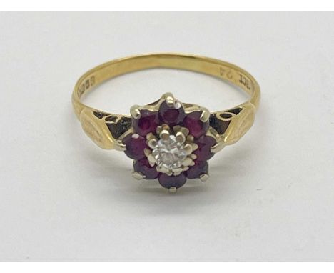 An 18ct Gold Diamond and Ruby Set Ring, of flowerhead design, collet set throughout between reeded band (finger size N1/2) (2