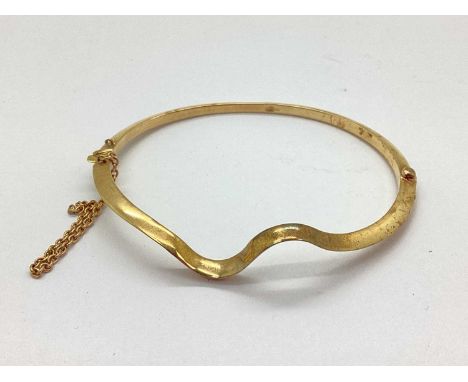 A 14ct Gold Hinged Bangle, of plain wavy design, hinged to snap clasp (safety chain part detached (7.5grams).