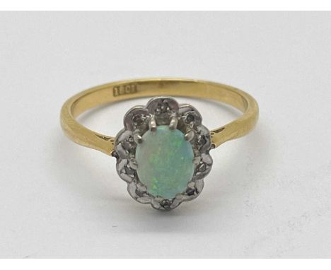 An Opal and Diamond Cluster Ring, the oval opal to illusion set border of scalloped design, between tapered band stamped "18c