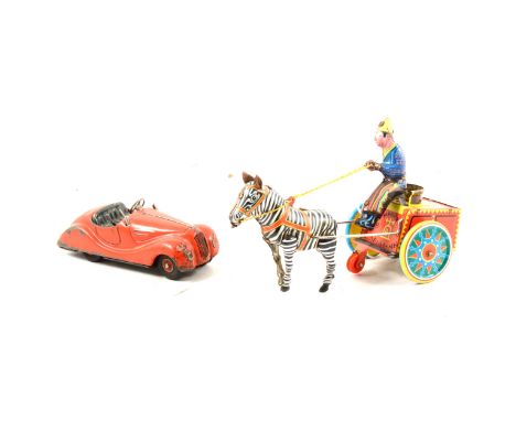 A Schuco clockwork sports car and a tinplate clockwork toy, a Zebra pulling a cart, (2).