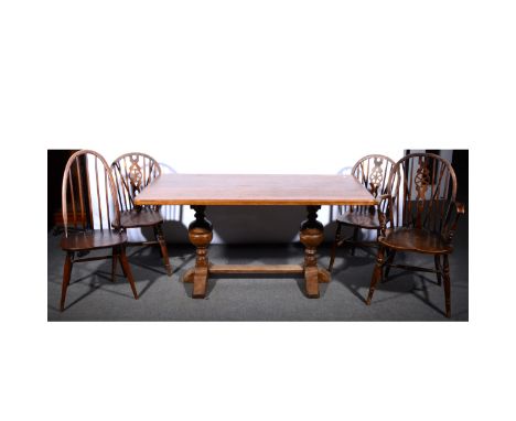 A reproduction oak kitchen table by Kirton, twin bulbous supports, 153cm x 76cm; three wheel-back Windsor type kitchen chairs