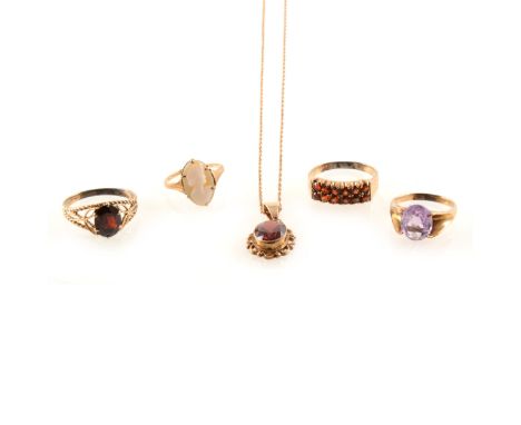 A garnet ring, claw set in 9 carat yellow gold, a garnet pendant in a 9 carat yellow gold setting on a chain stamped 9kt, and
