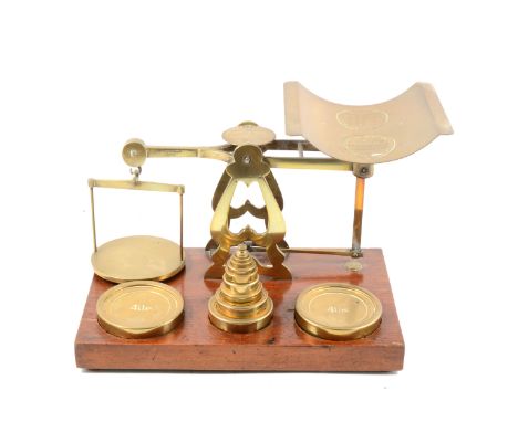 A set of brass postal balance scales, wooden platform, incorporating nest of weights, 4lbs and smaller.