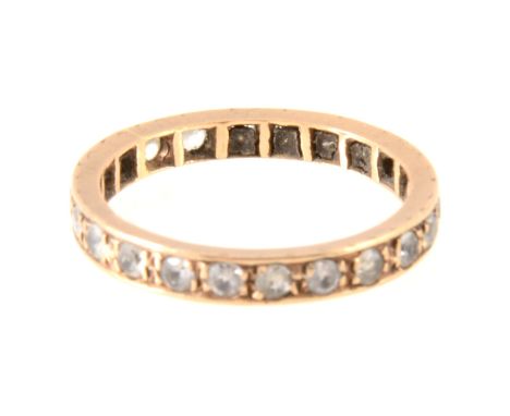 A synthetic white spinel full eternity ring, the stones line edge set in a 9 carat yellow gold mount 2.6mm wide, hallmarked L
