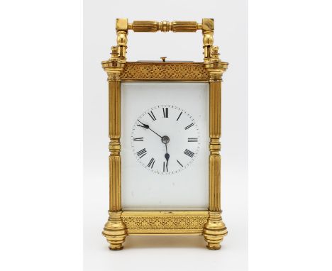A French gilt brass carriage clock, cast with columns to the corners, with pierced friezes to top and base, the white enamel 