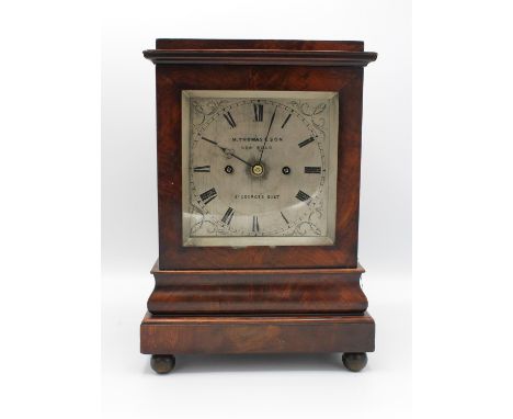 An early 19th Century mahogany cased mantle clock with glass panels to the top and sides, the silvered dial with Roman numera
