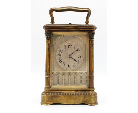 A late 19th century French brass cased carriage clock with push button repeat, visible escapement and a Gothic style silvered